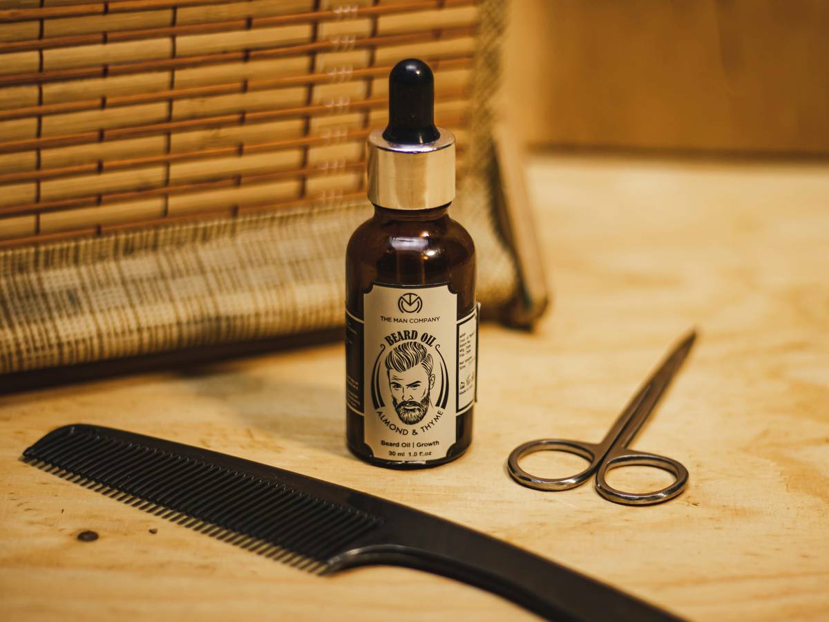 Man applying deeply moisturizing beard oil to his beard and jawline with fingertips